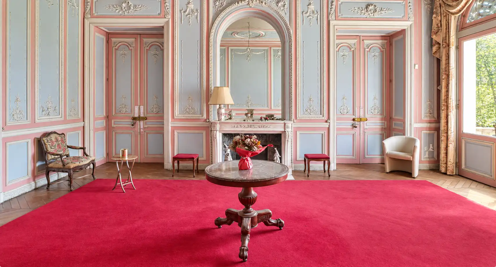 Grand salon du château aux boiseries bleu et rose, décor de tournage