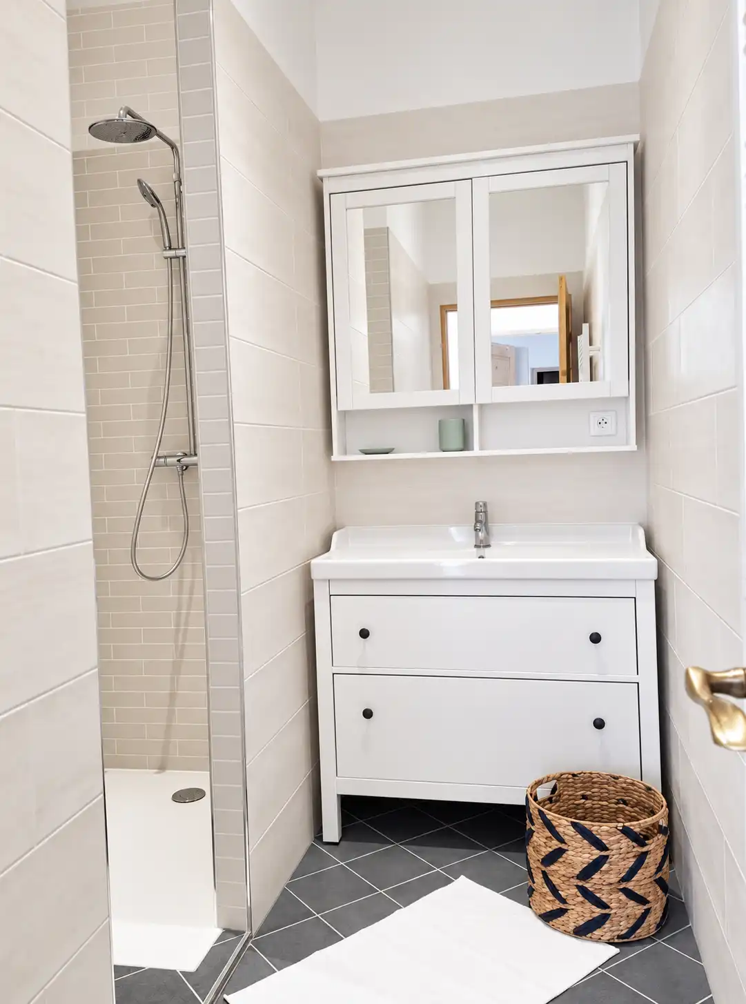 Douche à l'italienne, meuble vasque blanc et armoire à miroir dans la salle d'eau du Bon Espoir