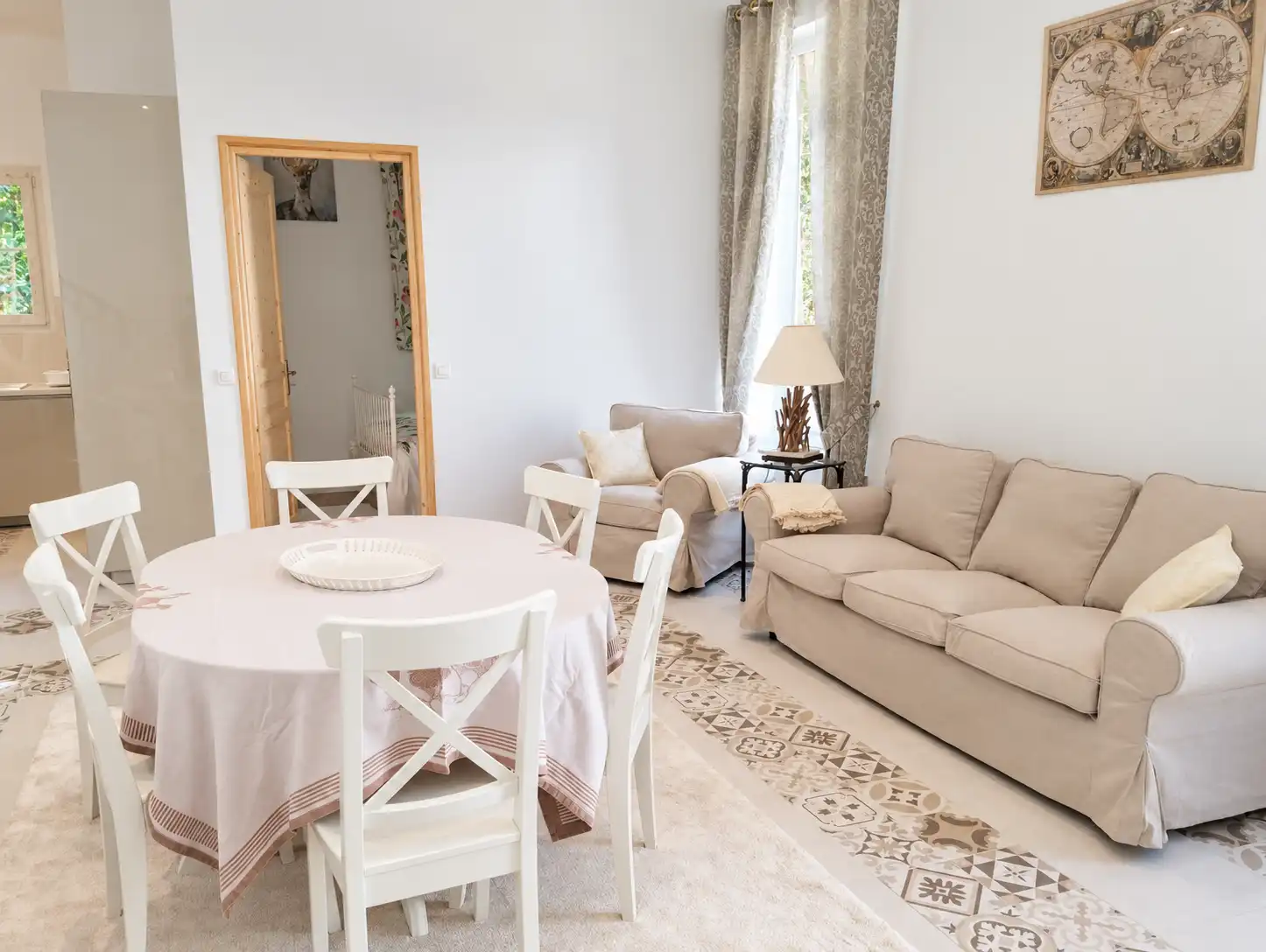 Canapé beige, fauteuil et table ronde avec chaises blanches dans le salon du Bon Espoir