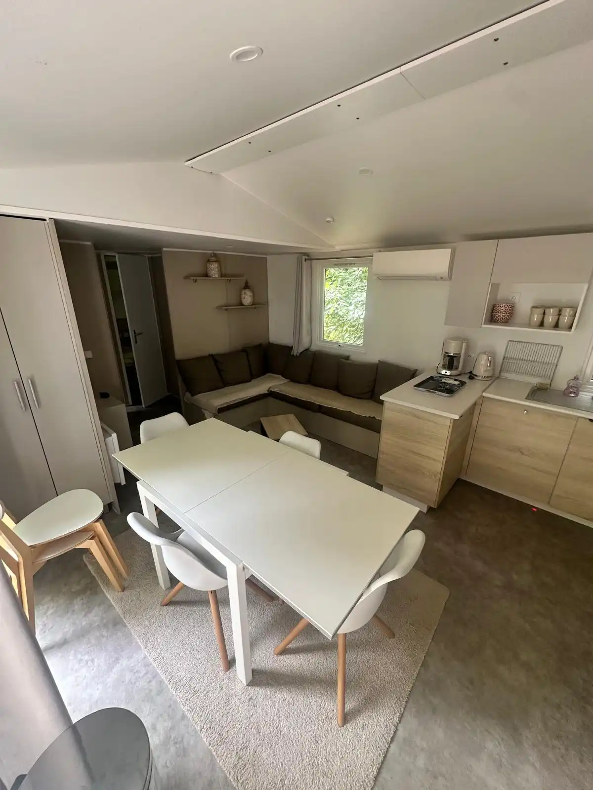 Table blanche et chaises devant la cuisine du Bungalow