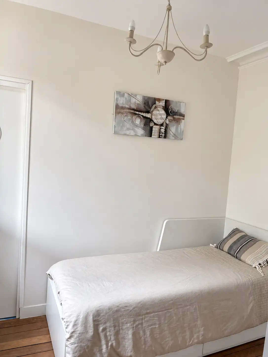 Chambre du Gardien avec lit simple convertible en lit double, porte ouverte sur la salle d'eau