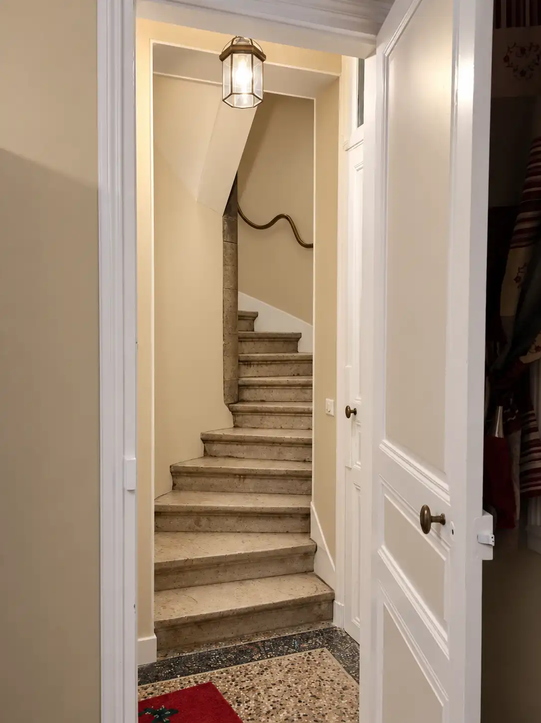 Escalier intérieur en pierre du Gardien vu depuis l'entrée au sol en mosaïque