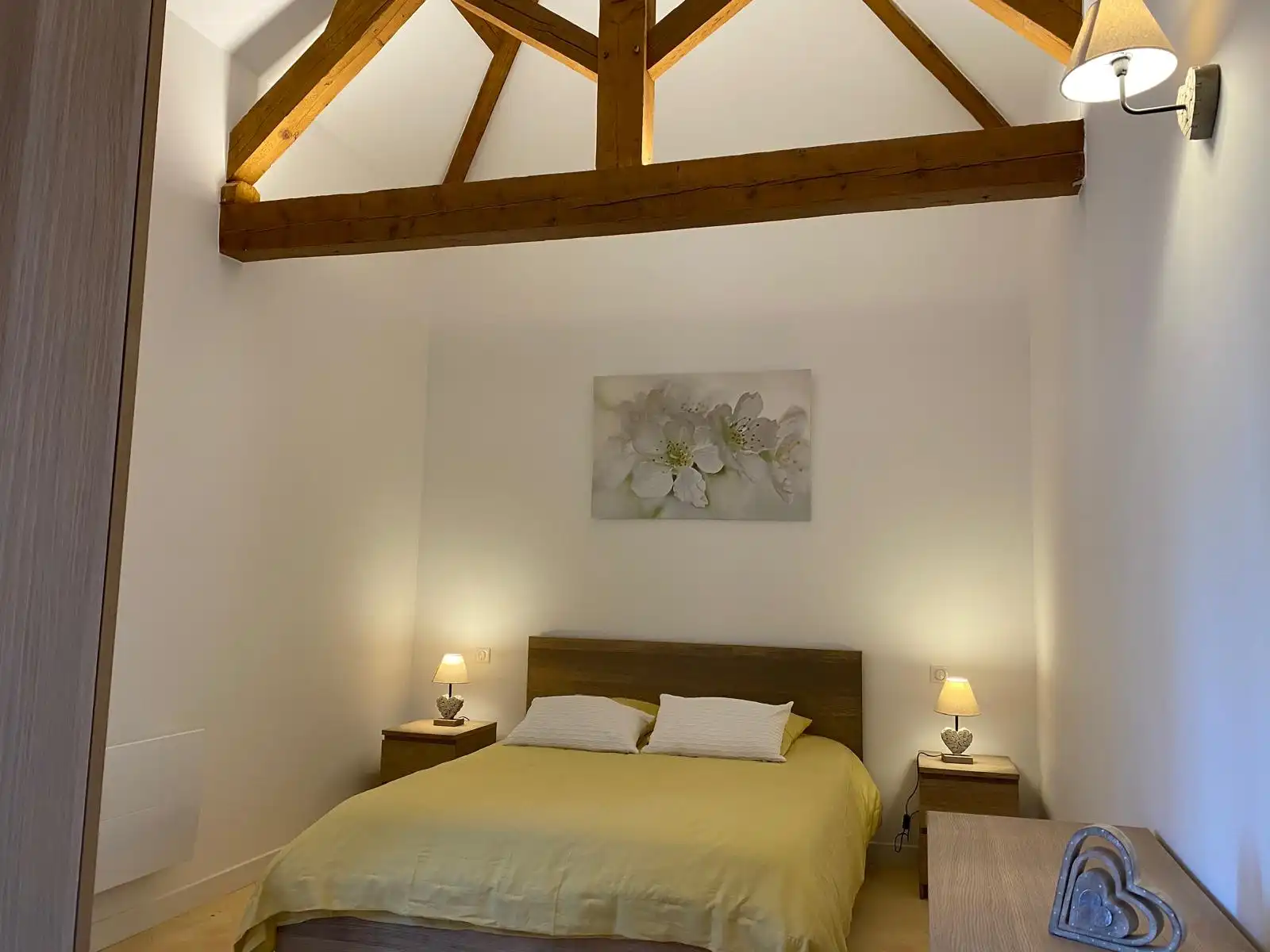 Chambre du Monarque aux poutres apparentes, lit double au dessus-de-lit vert et tableau floral