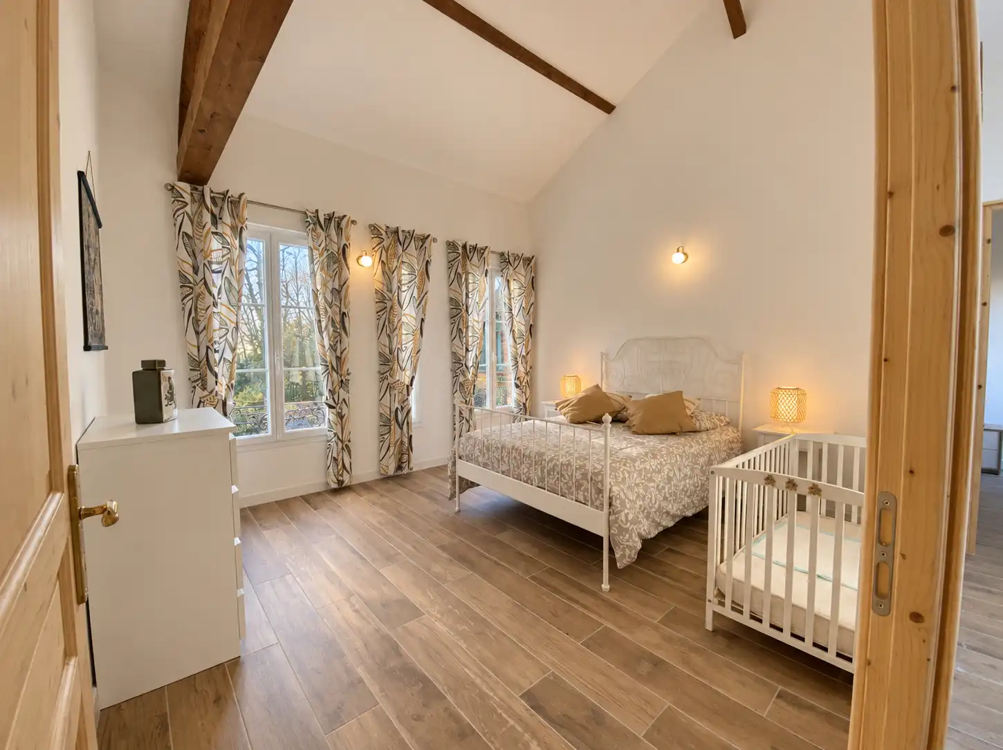 Chambre sous charpente du Monarque avec lit en fer blanc et lit à barreaux pour bébé