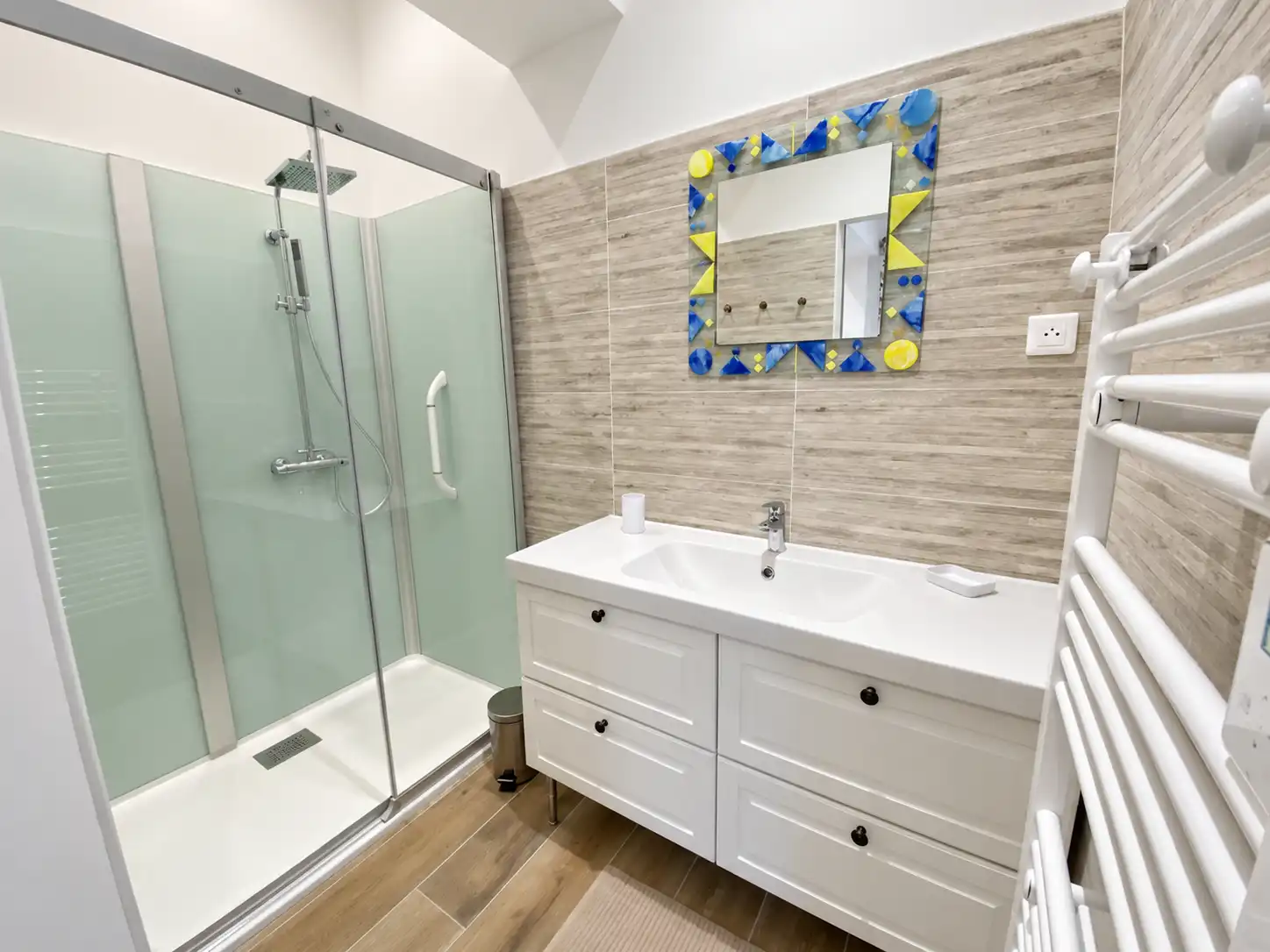 Grande douche vitrée, double vasque blanche et miroir en mosaïque colorée au Monarque